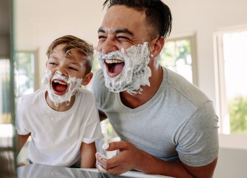 Father and son having fun while shaving in bathroom