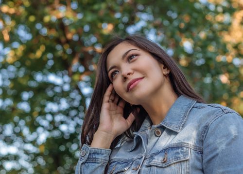 Portrait of a beautiful young Asian woman with dark hair in a park.