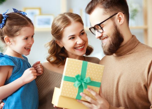 Mom and daughter congratulate dad and give him a gift