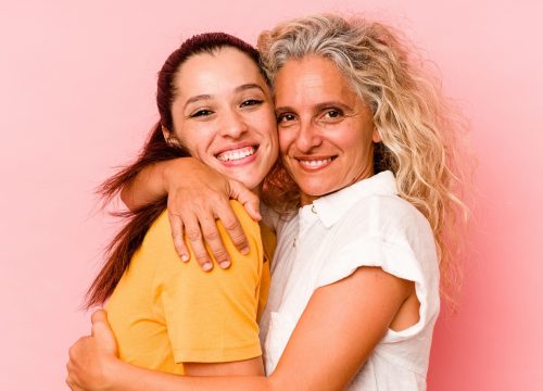 Mom and daughter isolated on pink background
