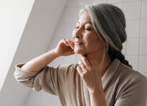 Photo of a woman touching her face after an AQUAGOLD fine touch treatment