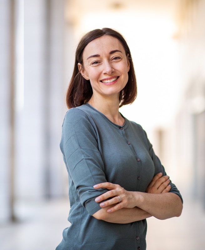 Portrait attractive older woman smiling with arms crossed