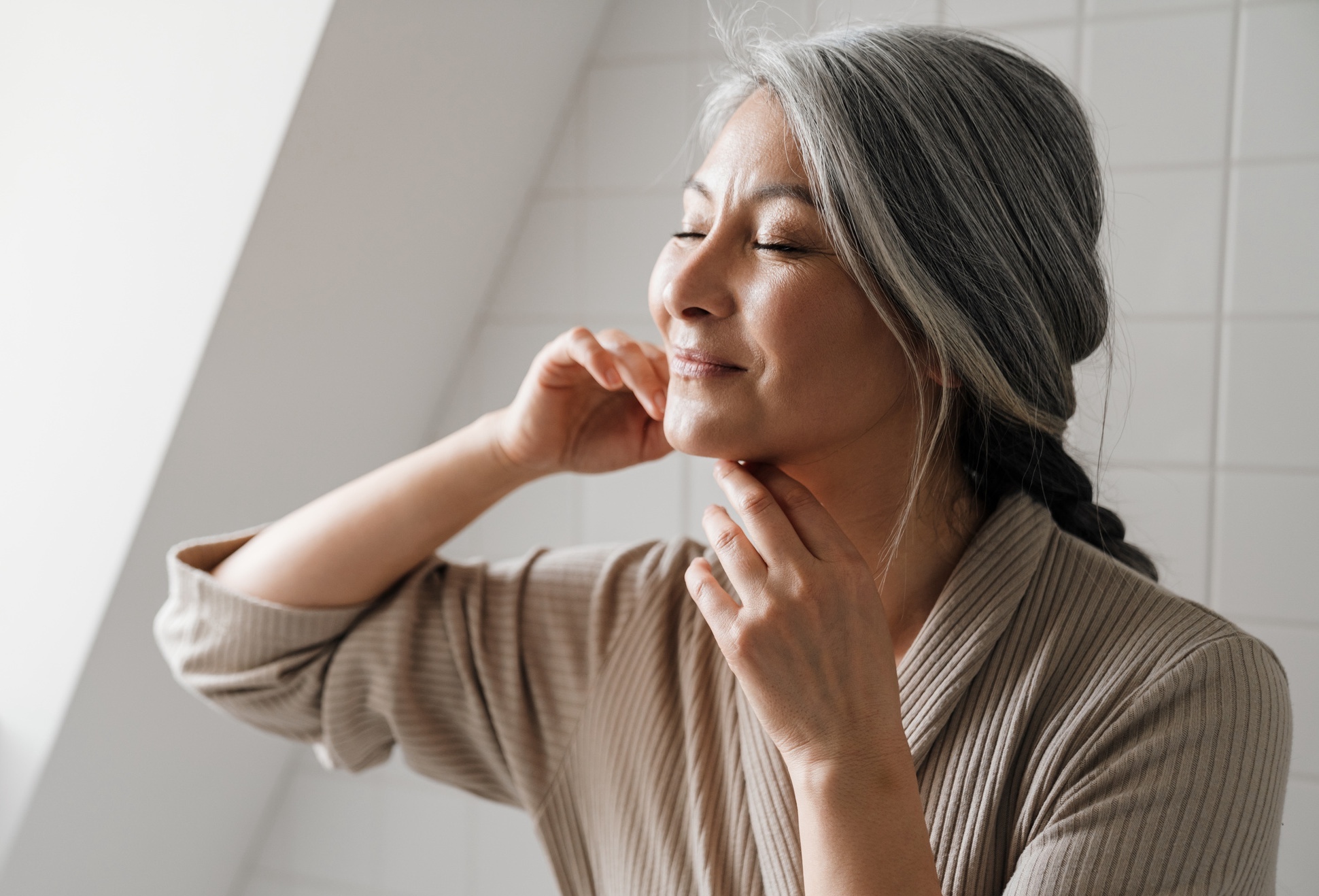 Photo of a woman touching her face after an AQUAGOLD fine touch treatment