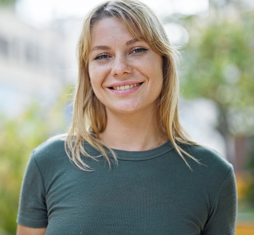 Young blonde woman smiling confident standing at park