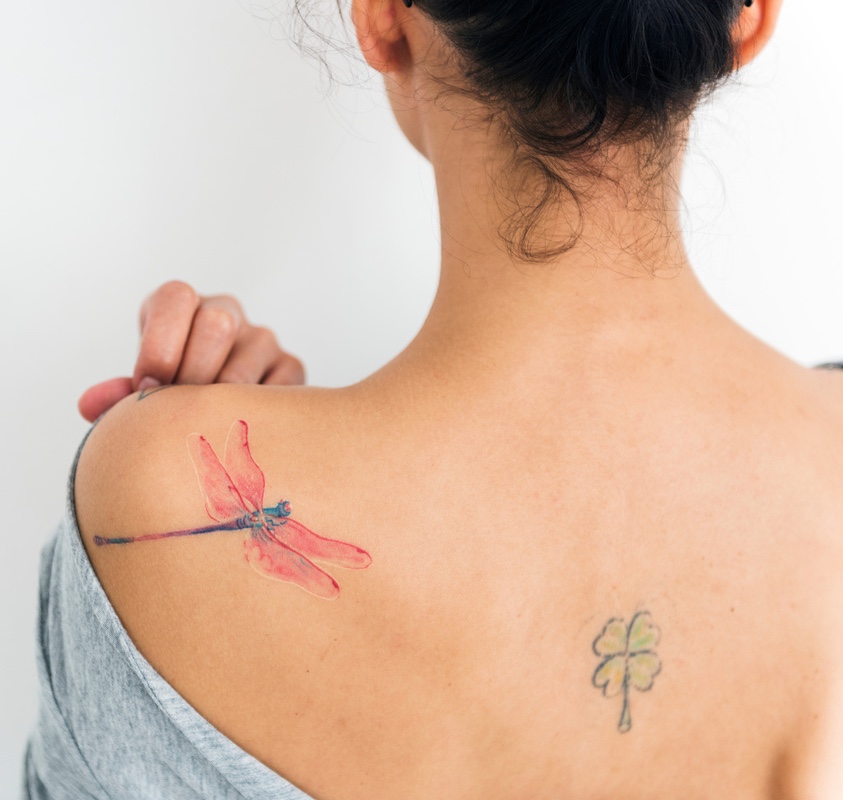 A woman is showing her tattoo on her back